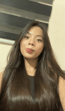a woman with long hair sticks her tongue out