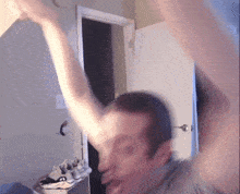 a blurry picture of a man 's face with his arms in the air