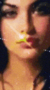 a close up of a woman 's face with a yellow flower in her mouth