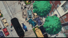 an aerial view of a busy street with cars parked on the sidewalk