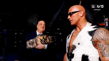 a man in a cow print vest is holding a world heavyweight championship belt .