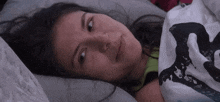 a woman is laying in bed with a blanket that says ' s ' on it