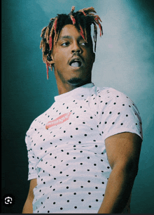 a man wearing a polka dot shirt with supreme on it