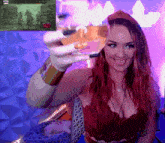 a woman in a red top is holding a glass in front of a screen that says youtube on it