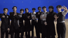 a group of men standing in front of a blue background