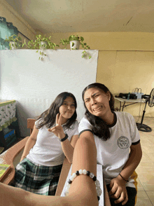 two girls pose for a picture with one wearing a shirt that says ' philippines '