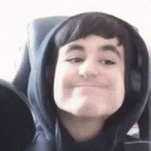 a close up of a person wearing a hoodie making a funny face .