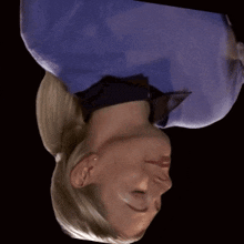 a woman with her eyes closed is wearing a blue sweater