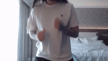 a man in a white shirt is dancing in a hotel room .