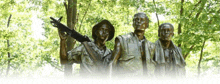 a statue of three soldiers standing next to each other holding guns