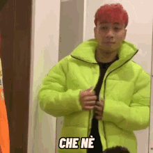 a man with red hair is wearing a neon green jacket with the words che ne written on it