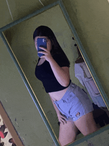 a woman taking a selfie in a mirror with her phone