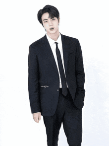 a man in a suit is standing in a kitchen
