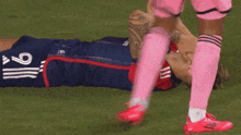 a soccer player with the number 9 on his shorts is laying on the field