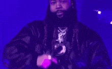 a man with a beard is wearing a black hat and a fur coat .