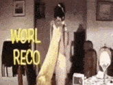a woman in a white dress is standing in a living room holding a yellow cloth .