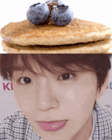 a close up of a person 's face next to a stack of pancakes and blueberries