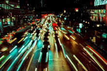 a blurry picture of a city street at night with a sign that says ' coca cola ' on it
