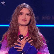 a woman holding a microphone with the words thank you below her