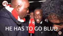 a man talking into a microphone with the words he has to go blud above him
