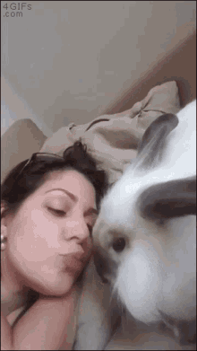 a woman kissing a rabbit on the cheek with a 4gifs.com watermark on the bottom