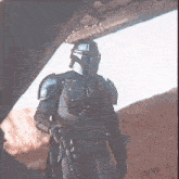 a man in armor is holding a gun in the desert ..