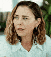 a close up of a woman 's face with a white shirt on