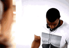 a man wearing headphones and a t-shirt that has a picture of a boat on it