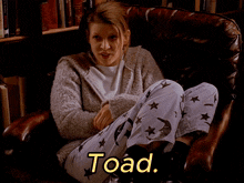 a woman is sitting in a chair with the word toad written in yellow