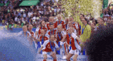 a group of soccer players are celebrating with a trophy in front of a banner that says uefa league