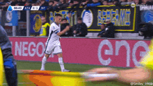 a soccer player is celebrating a goal in front of a banner that says nego