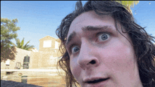 a close up of a man 's face with a swimming pool in the background