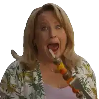 a woman is holding a skewer in her mouth