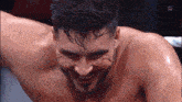 a man without a shirt is smiling with a w logo in the background