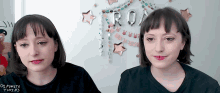 two women standing next to each other in front of a sign that says roam