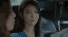 a woman in a car with kbs2 written on the bottom