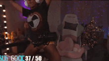 a woman with blonde dreadlocks is dancing in a room with a christmas tree in the background .