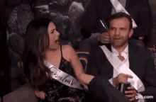 a man and a woman are sitting next to each other on a couch .