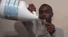 a man pouring bleach into a glass with ice