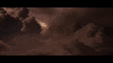 a red winged creature is flying through the air in a dark room