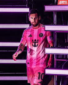 a man wearing a pink jersey with the number 10 on the shorts