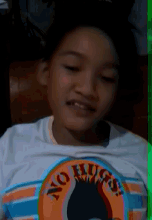 a young boy wearing a no hugs shirt
