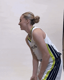 a woman wearing a gs jersey stands with her hands in her pockets