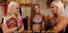 three female wrestlers are standing next to each other in a locker room and talking .