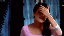 a woman with a ring on her finger covering her face with her hand and the words lez.net below her