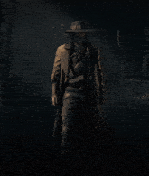a man in a long coat and hat is standing in a dark forest
