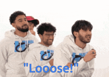 a group of men standing next to each other with the words " looose " written in blue