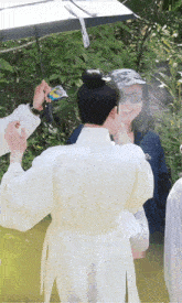 a man in a white robe with a bun on his head is being photographed