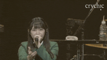 a woman singing into a microphone with the word crychic in the background