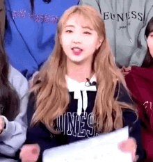 a girl with blonde hair is wearing a black shirt that says euness on it